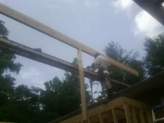 Carpenter setting a ridge beam over a new addition frame — Ice Dam Removal by Roofing Brothers in Roseland