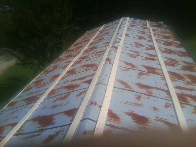 Rusted metal roof panels with new wood purlins before replacement — Storm Damage Roof Repair in Roseland by Roofing Brothers